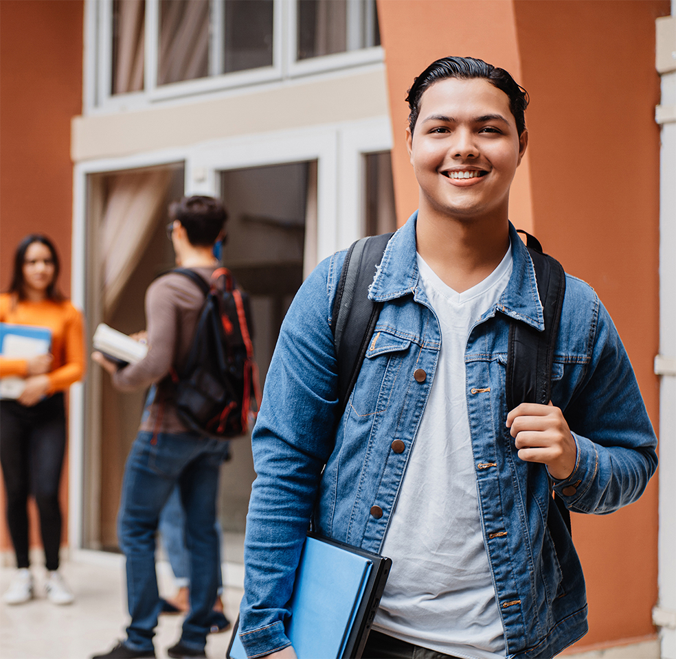 Young male student in the foregound smiling 